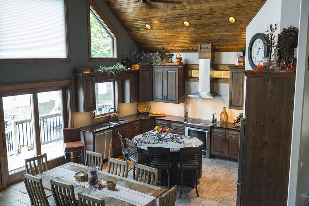 Inspiration for a rustic porcelain tile kitchen remodel with an undermount sink, raised-panel cabinets, distressed cabinets, granite countertops and stainless steel appliances