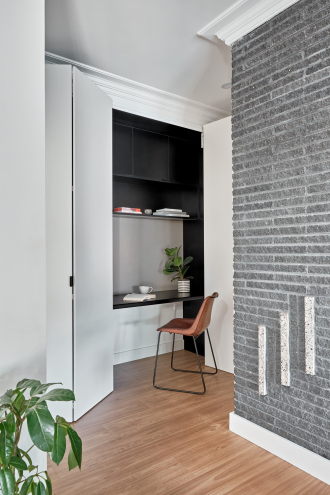 Diseño de despacho actual pequeño con suelo de madera clara, escritorio empotrado y suelo beige