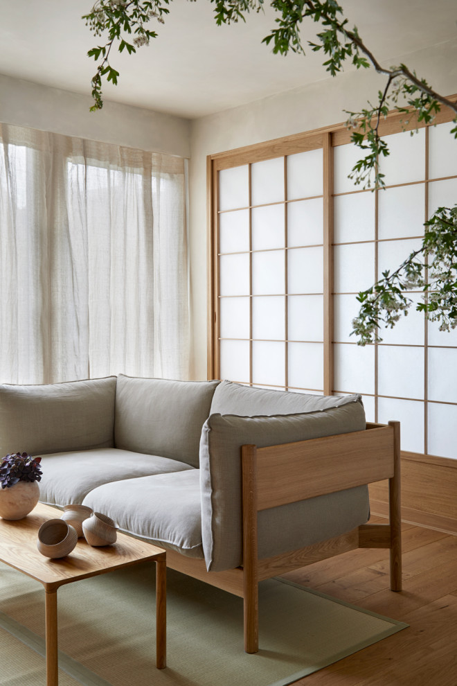 Diseño de salón abierto de estilo zen pequeño con suelo de madera clara y televisor colgado en la pared