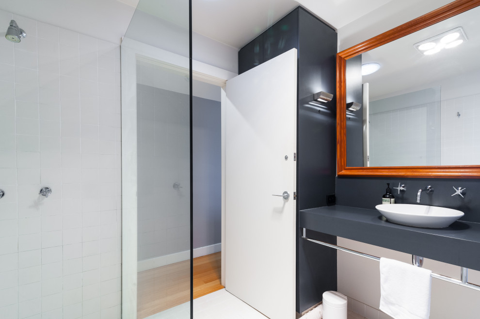 Mid-sized contemporary 3/4 bathroom in Sydney with white cabinets, an open shower, a one-piece toilet, white tile, porcelain tile, white walls, ceramic floors, laminate benchtops, white floor, an open shower, grey benchtops, a single vanity and a floating vanity.