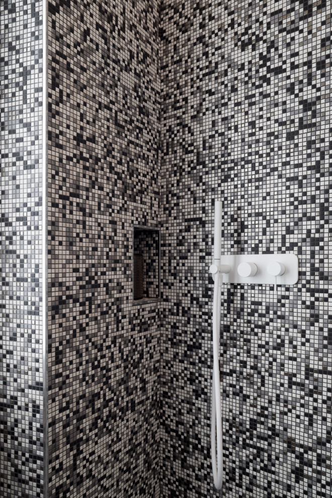 Photo of a small contemporary shower room bathroom in Cagliari with a built-in shower, a two-piece toilet, black and white tiles, white walls, mosaic tile flooring, a vessel sink, a sliding door, white worktops, a single sink and a wall niche.