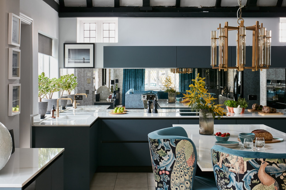 Foto di una cucina moderna di medie dimensioni con lavello da incasso, ante lisce, ante grigie, top in superficie solida, paraspruzzi a specchio, elettrodomestici neri, top bianco e travi a vista