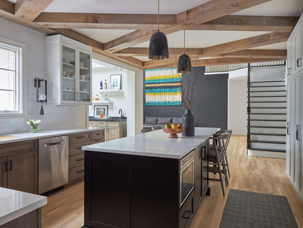 Example of a large transitional u-shaped medium tone wood floor, brown floor and exposed beam eat-in kitchen design in Chicago with an undermount sink, recessed-panel cabinets, white cabinets, quartz countertops, white backsplash, ceramic backsplash, paneled appliances, an island and white countertops