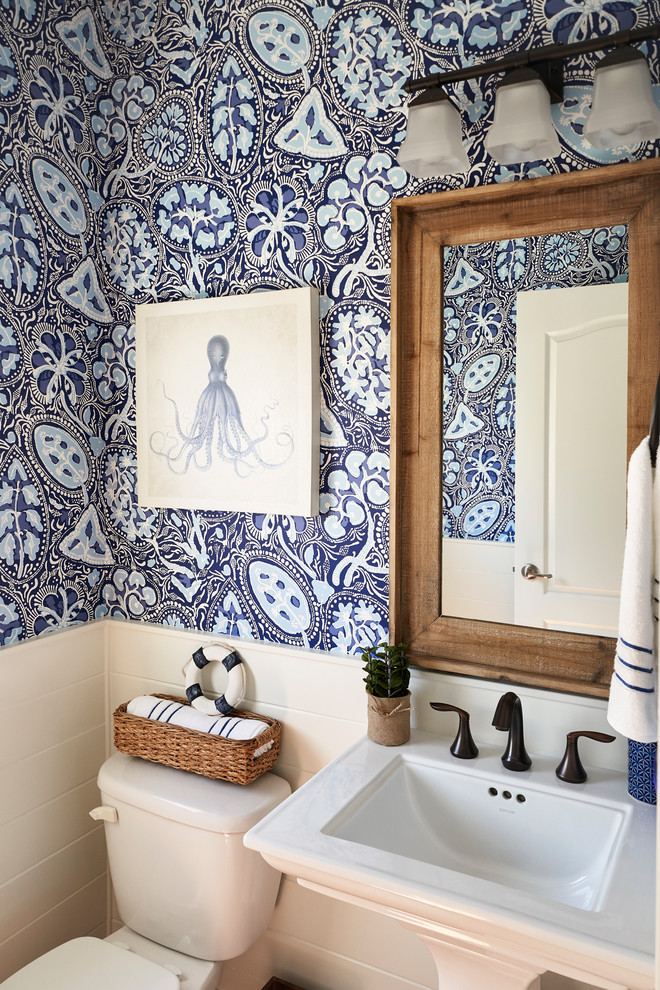 This is an example of a beach style powder room in Philadelphia with a two-piece toilet, blue walls and a pedestal sink.