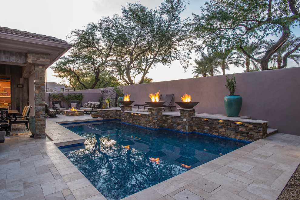 Photo of a mid-sized transitional backyard l-shaped natural pool in Phoenix with natural stone pavers and a water feature.
