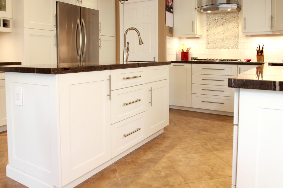 Example of a mid-sized transitional u-shaped porcelain tile and brown floor eat-in kitchen design in Phoenix with an undermount sink, shaker cabinets, white cabinets, white backsplash, subway tile backsplash, stainless steel appliances, an island, granite countertops and brown countertops