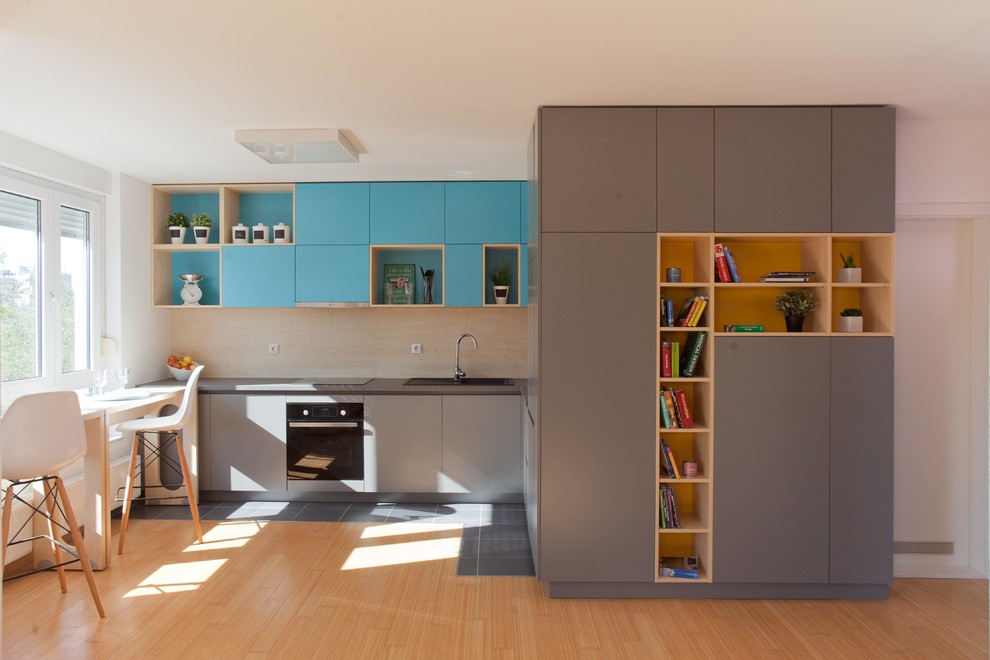Small contemporary l-shaped eat-in kitchen in Other with a single-bowl sink, blue cabinets, laminate benchtops, beige splashback, stainless steel appliances, ceramic floors and no island.