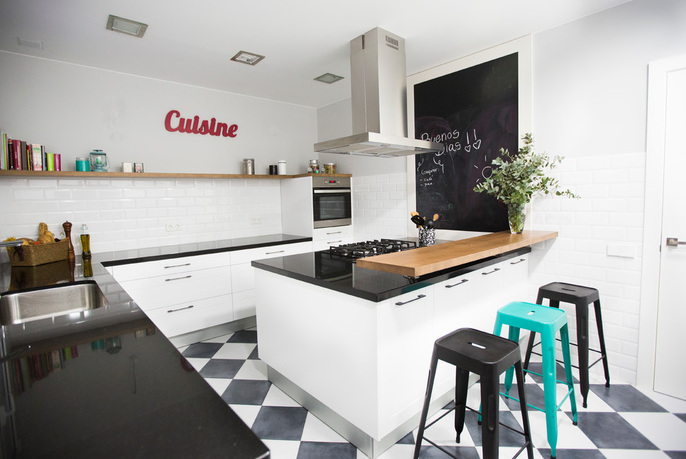 Design ideas for a large industrial u-shaped separate kitchen in Barcelona with an undermount sink, flat-panel cabinets, white cabinets, solid surface benchtops, white splashback, subway tile splashback, stainless steel appliances, ceramic floors and with island.