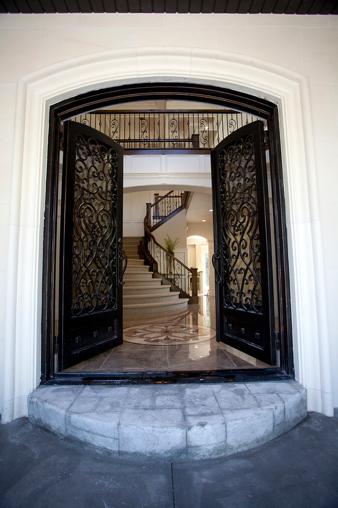 This is an example of a large traditional front door in Salt Lake City with beige walls, marble floors, a double front door and a black front door.