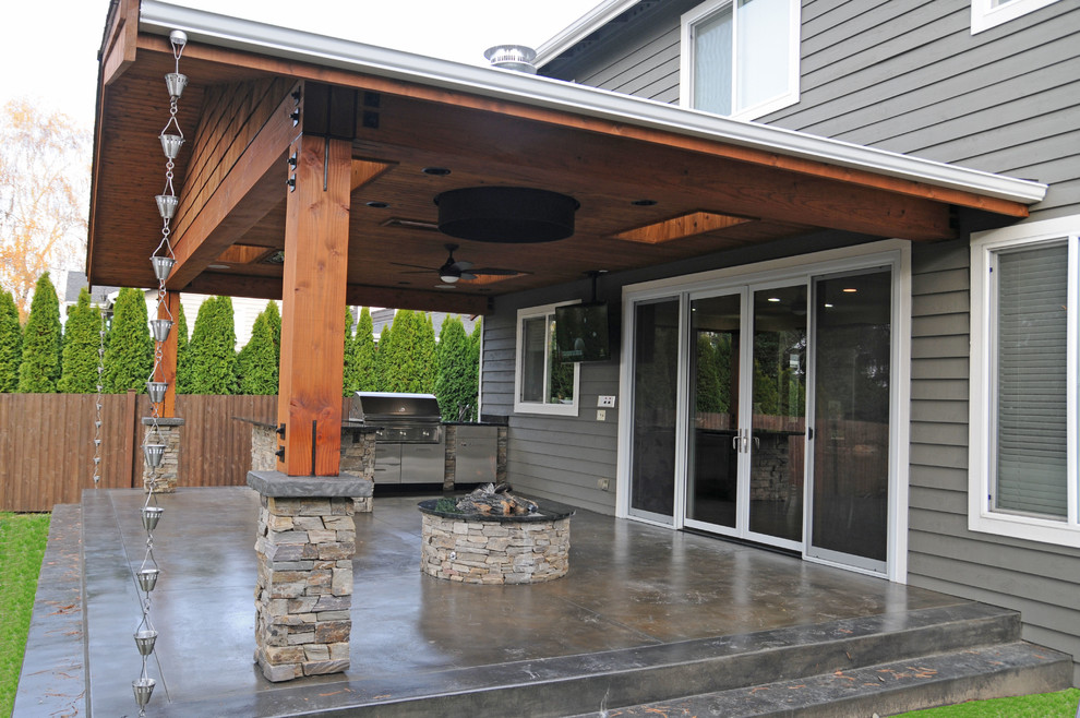 Inspiration for a mid-sized arts and crafts backyard patio in Seattle with a fire feature, concrete slab and a pergola.