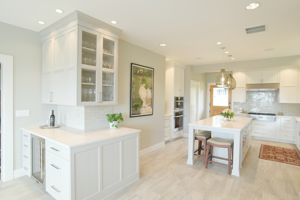 Transitional ceramic tile kitchen photo in Seattle with shaker cabinets, white cabinets, quartzite countertops, subway tile backsplash, stainless steel appliances, an island and white countertops