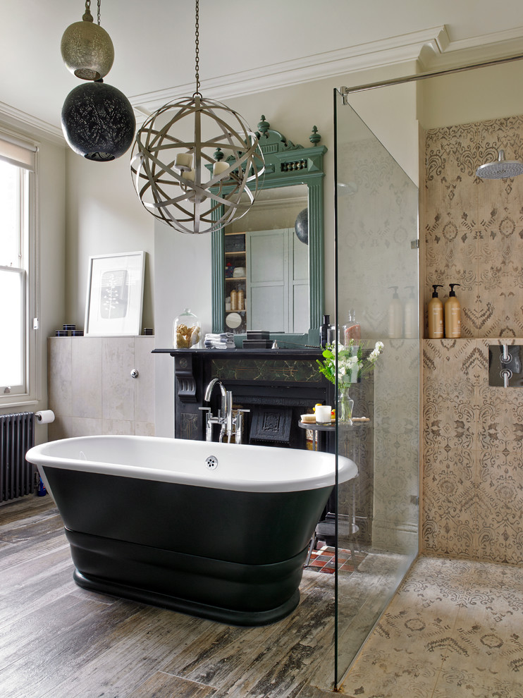 Mediterranean master bathroom in London with a freestanding tub, a corner shower, beige tile, brown tile, beige walls, medium hardwood floors and an open shower.