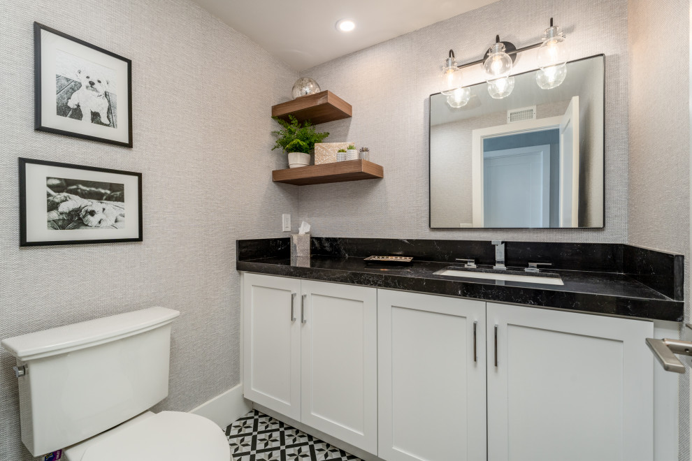 Maritim inredning av ett mellanstort svart svart badrum, med skåp i shakerstil, vita skåp, en toalettstol med separat cisternkåpa, grå väggar, cementgolv, ett undermonterad handfat och bänkskiva i kvarts