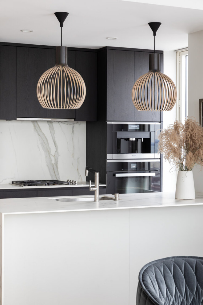 Immagine di una piccola cucina moderna con lavello sottopiano, ante lisce, ante nere, paraspruzzi bianco, elettrodomestici da incasso, parquet chiaro, pavimento beige e top bianco