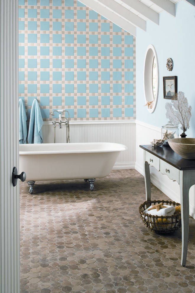 This is an example of a mid-sized beach style master bathroom in Austin with a claw-foot tub, blue tile, ceramic tile, blue walls, brick floors and beige floor.