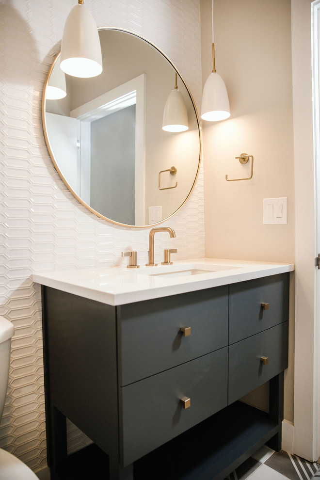 This is an example of a mid-sized transitional powder room in Austin with flat-panel cabinets, white tile, ceramic tile, white walls, engineered quartz benchtops, white benchtops, cement tiles, an undermount sink, multi-coloured floor and grey cabinets.