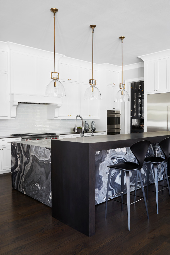 Inspiration for a large contemporary l-shaped open plan kitchen in Dallas with an undermount sink, recessed-panel cabinets, white cabinets, quartzite benchtops, black splashback, glass tile splashback, stainless steel appliances, dark hardwood floors, with island, brown floor and black benchtop.