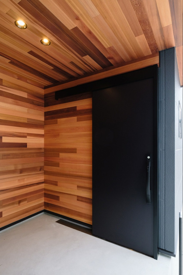 Свежая идея для дизайна: фойе с коричневыми стенами, раздвижной входной дверью, черной входной дверью, деревянным потолком и деревянными стенами - отличное фото интерьера
