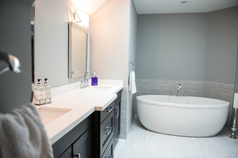 Mid-sized contemporary master bathroom in Toronto with shaker cabinets, black cabinets, a freestanding tub, gray tile, ceramic tile, grey walls, ceramic floors, an undermount sink and granite benchtops.