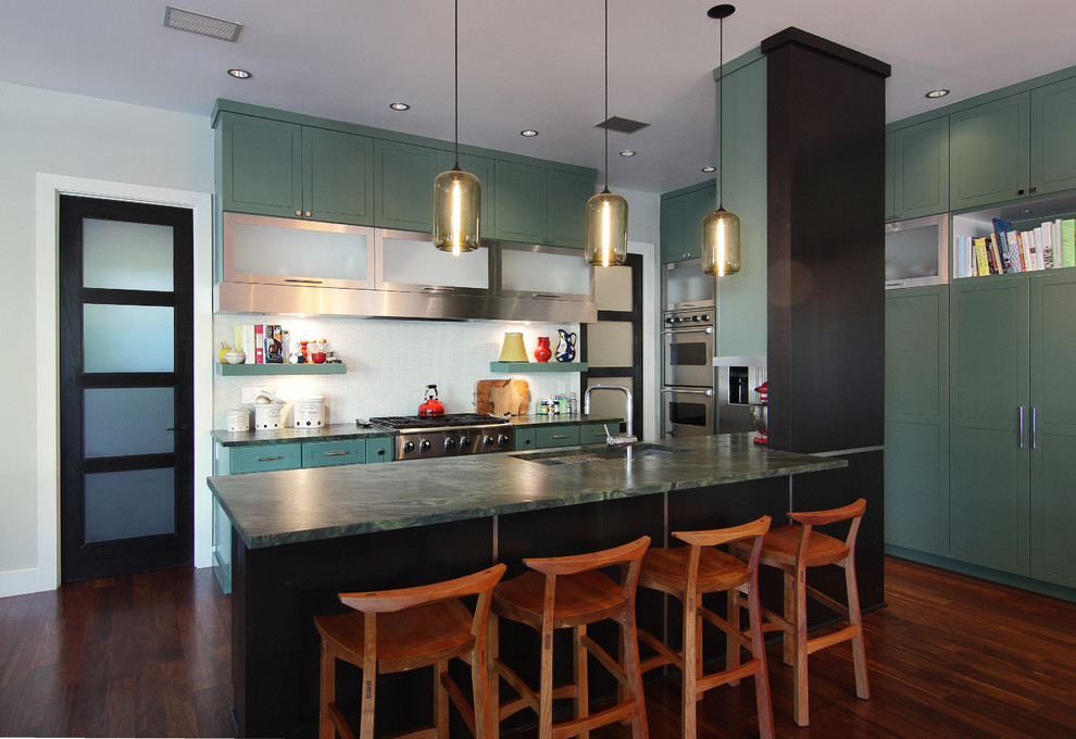 Contemporary kitchen in Austin with stainless steel appliances and green cabinets.