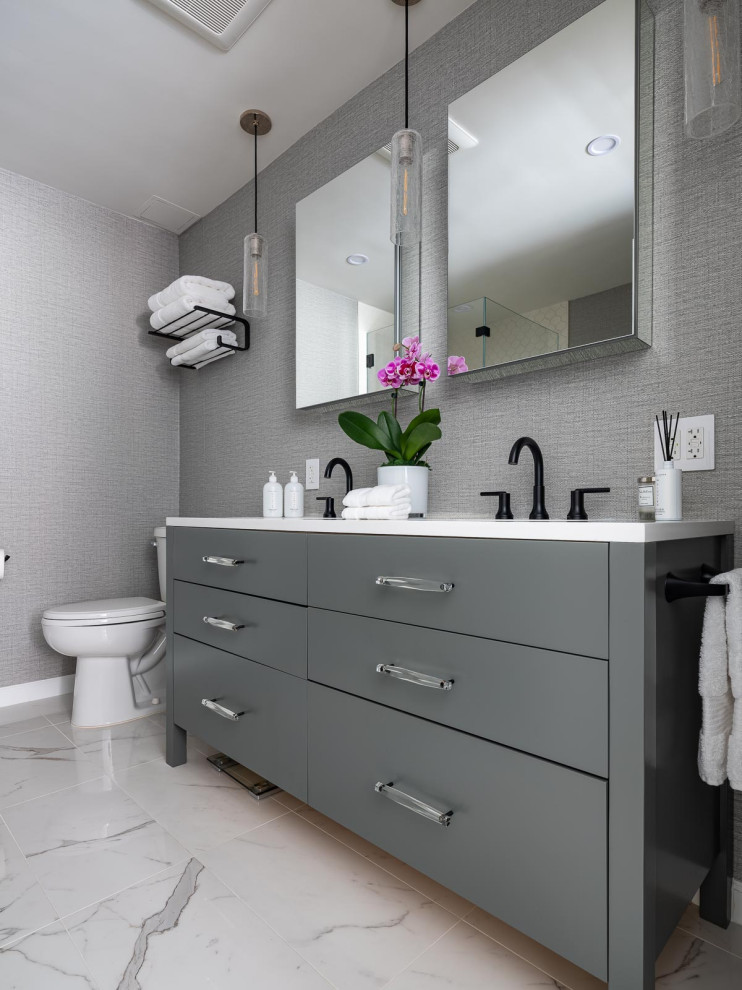 Photo of a transitional master bathroom in New York with shaker cabinets, grey cabinets, a freestanding tub, a corner shower, a two-piece toilet, white tile, porcelain tile, grey walls, ceramic floors, an undermount sink, engineered quartz benchtops, white floor, a hinged shower door, white benchtops, a double vanity and a freestanding vanity.