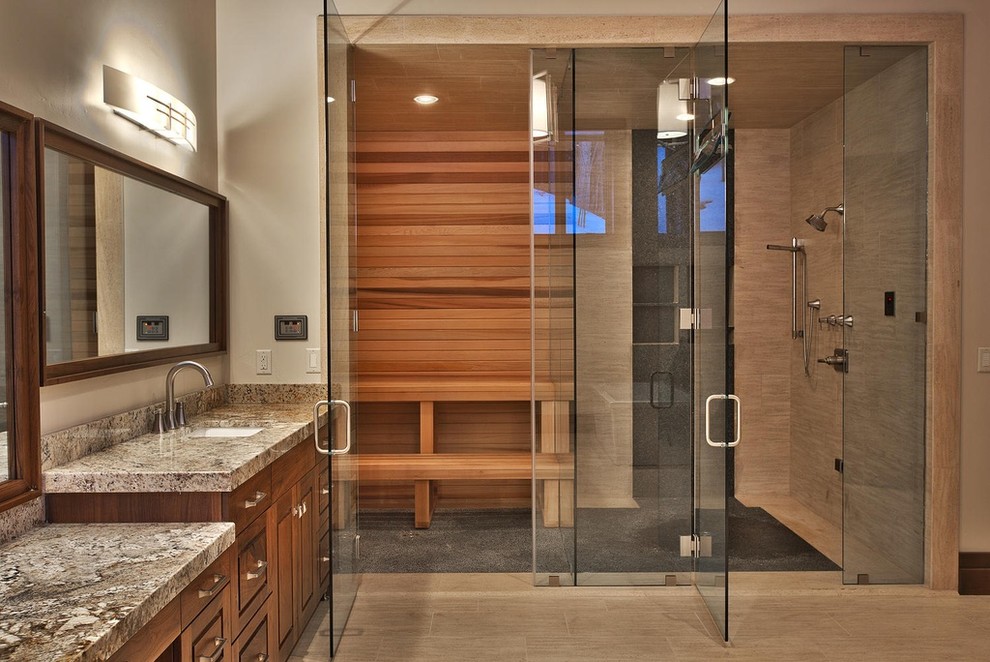 Expansive contemporary bathroom in Salt Lake City with raised-panel cabinets, dark wood cabinets, an alcove shower, beige tile, porcelain tile, grey walls, porcelain floors, with a sauna, an undermount sink, granite benchtops, beige floor and a hinged shower door.