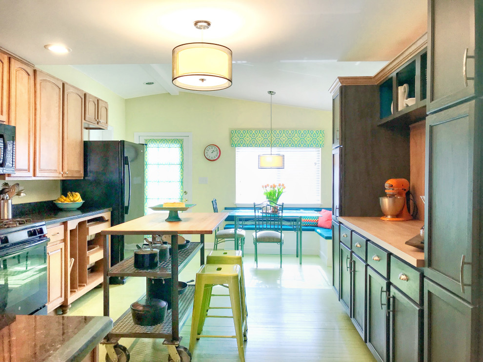 This is an example of a mid-sized transitional eat-in kitchen in Columbus with a drop-in sink, recessed-panel cabinets, medium wood cabinets, granite benchtops, green splashback, black appliances, painted wood floors, with island, green floor and green benchtop.