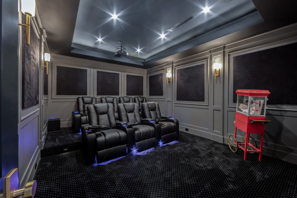 Transitional enclosed home theatre in Los Angeles with grey walls, carpet and black floor.