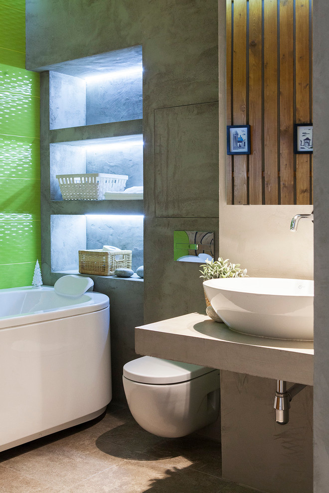 Contemporary master bathroom in Moscow with open cabinets, a freestanding tub, a wall-mount toilet, green tile, grey walls and a vessel sink.
