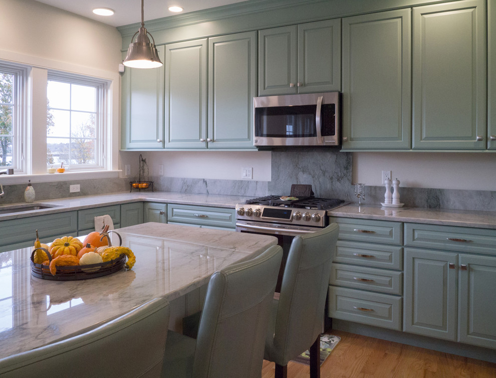 Design ideas for a large beach style eat-in kitchen in Providence with a drop-in sink, raised-panel cabinets, blue cabinets, granite benchtops, blue splashback, ceramic splashback, stainless steel appliances, light hardwood floors and with island.