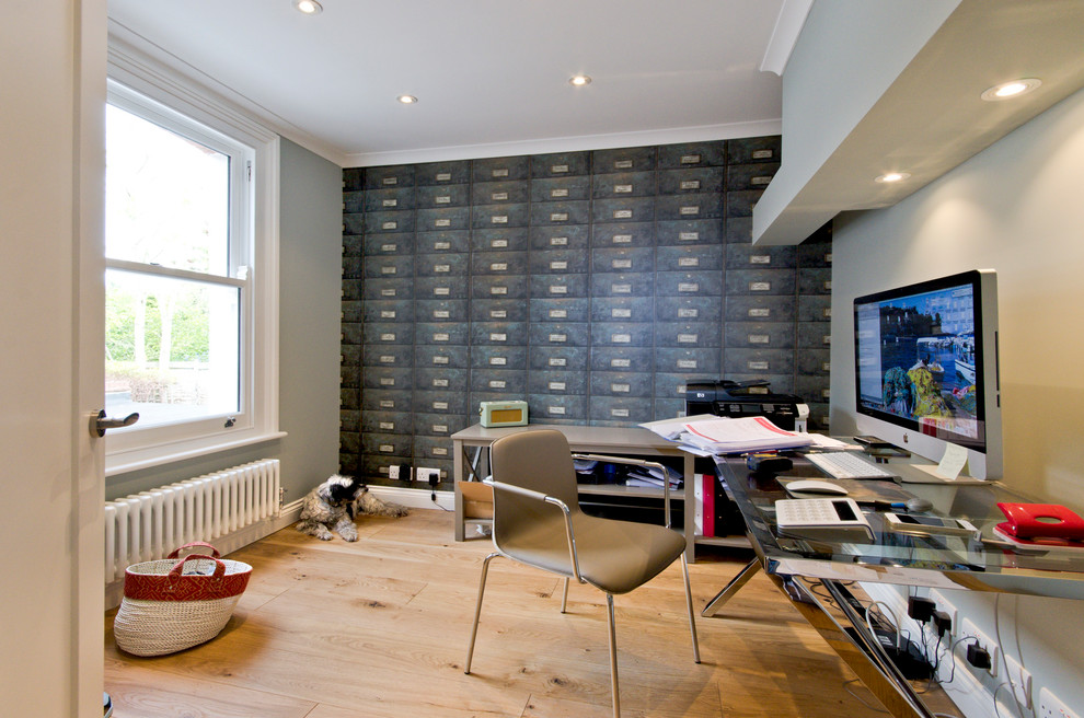 Photo of a modern home office in London with grey walls, light hardwood flooring and a freestanding desk.