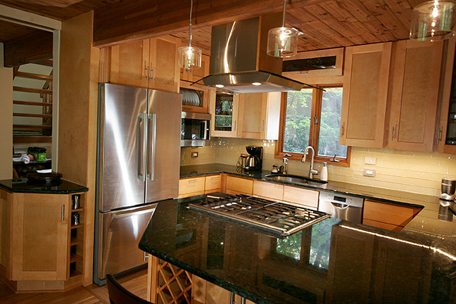 Small transitional l-shaped porcelain tile eat-in kitchen photo with shaker cabinets, light wood cabinets, granite countertops, beige backsplash, glass tile backsplash, stainless steel appliances and a peninsula