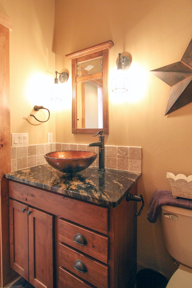 Mountain style beige tile and stone tile bathroom photo with a vessel sink, medium tone wood cabinets and granite countertops