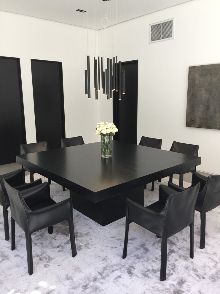 This is an example of a large contemporary open plan dining in Los Angeles with white walls, carpet, no fireplace and grey floor.