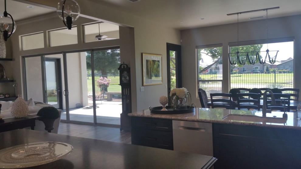 Inspiration for a large transitional u-shaped brown floor open concept kitchen remodel with an undermount sink, recessed-panel cabinets, dark wood cabinets, granite countertops, beige backsplash, porcelain backsplash, stainless steel appliances and an island