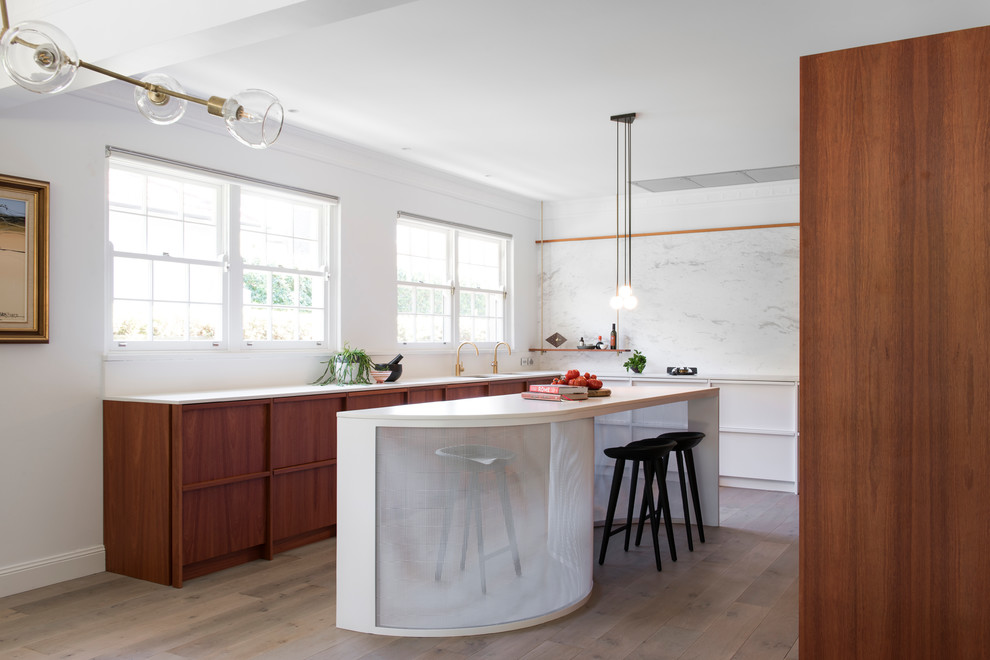 Inspiration for a large contemporary u-shaped kitchen in Sydney with an undermount sink, white cabinets, quartz benchtops, white splashback, marble splashback, with island, flat-panel cabinets, medium hardwood floors, brown floor and white benchtop.