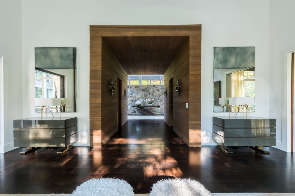 Immagine di un grande ingresso o corridoio minimalista con pareti bianche, parquet scuro, pavimento marrone e pareti in legno