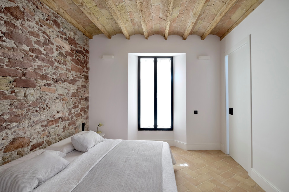 Ejemplo de dormitorio principal, abovedado y beige y blanco rústico grande sin chimenea con paredes marrones, suelo de baldosas de terracota, suelo beige y ladrillo