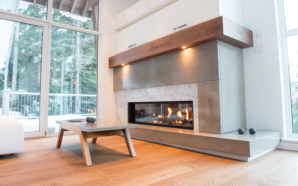 Mid-sized contemporary open concept living room in Vancouver with white walls, light hardwood floors, a standard fireplace and a concrete fireplace surround.