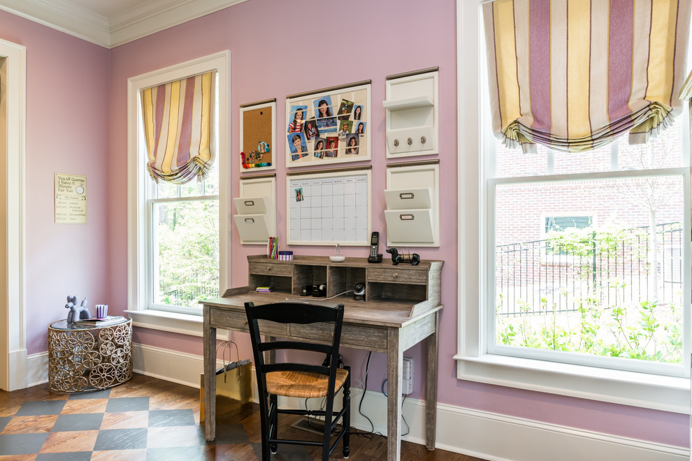 This is an example of a mid-sized transitional home office in Atlanta with dark hardwood floors, a freestanding desk, brown floor and pink walls.