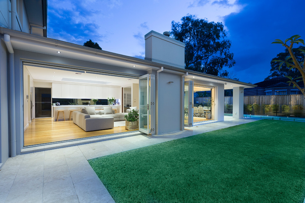 Photo of a contemporary two-storey stucco white exterior in Sydney with a hip roof.