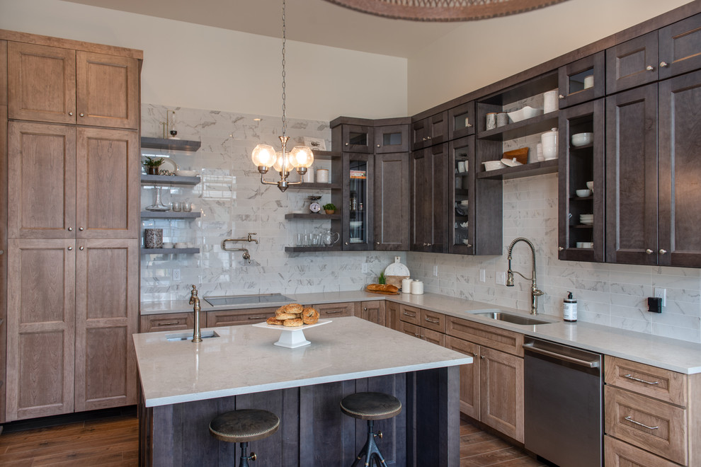 This is an example of a transitional l-shaped kitchen in Salt Lake City with an undermount sink, shaker cabinets, brown cabinets, white splashback, stone tile splashback, dark hardwood floors, with island and grey benchtop.