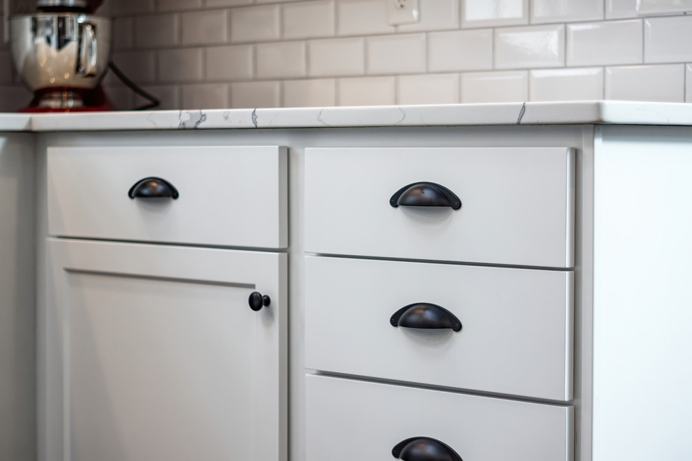 Inspiration for a large transitional u-shaped eat-in kitchen remodel in Columbus with shaker cabinets, quartz countertops, white backsplash and an island