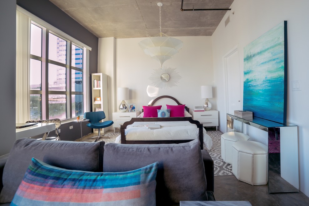 This is an example of a mid-sized transitional loft-style bedroom in Miami with white walls, concrete floors, no fireplace and brown floor.
