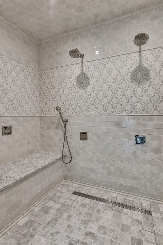 This is an example of a large transitional master bathroom in New York with beaded inset cabinets, white cabinets, a drop-in tub, an alcove shower, a two-piece toilet, beige tile, ceramic tile, grey walls, porcelain floors, an undermount sink, engineered quartz benchtops, beige floor, a hinged shower door and beige benchtops.