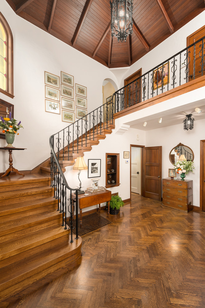 This is an example of a large mediterranean foyer in San Francisco with white walls, medium hardwood floors and brown floor.