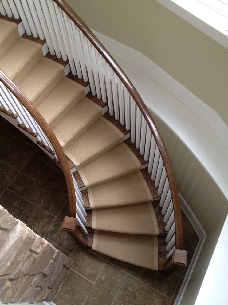 This is an example of a mid-sized transitional wood curved staircase in Chicago.