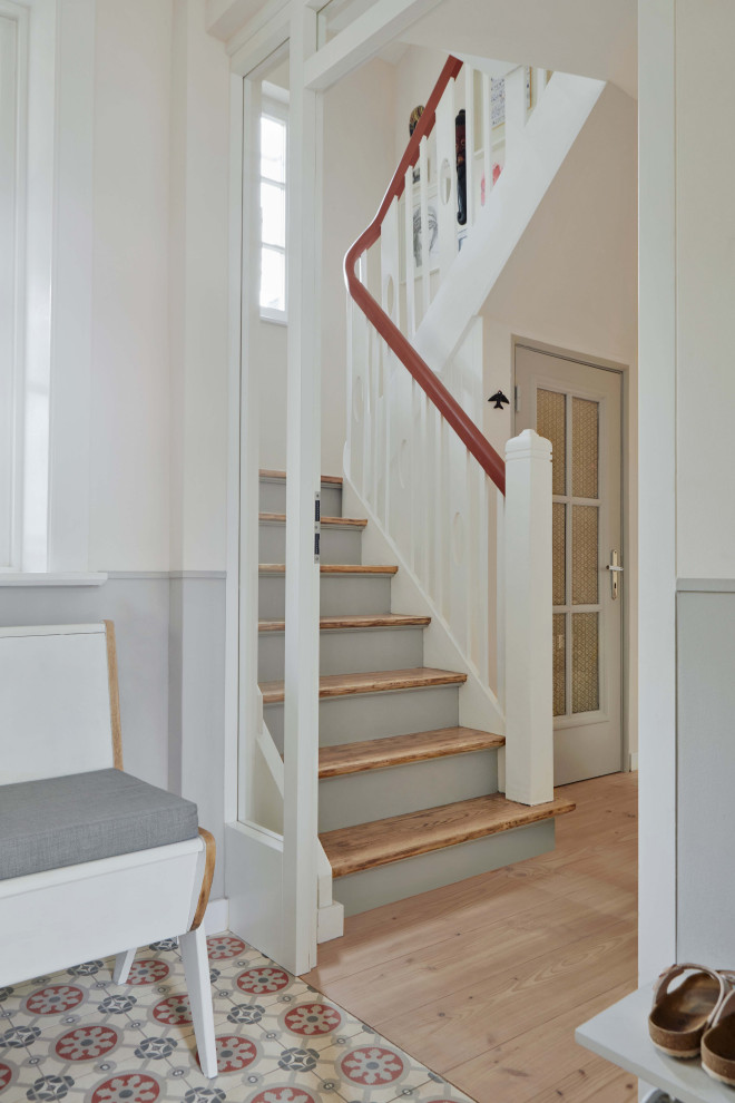 Ejemplo de escalera curva nórdica con escalones de madera y barandilla de madera