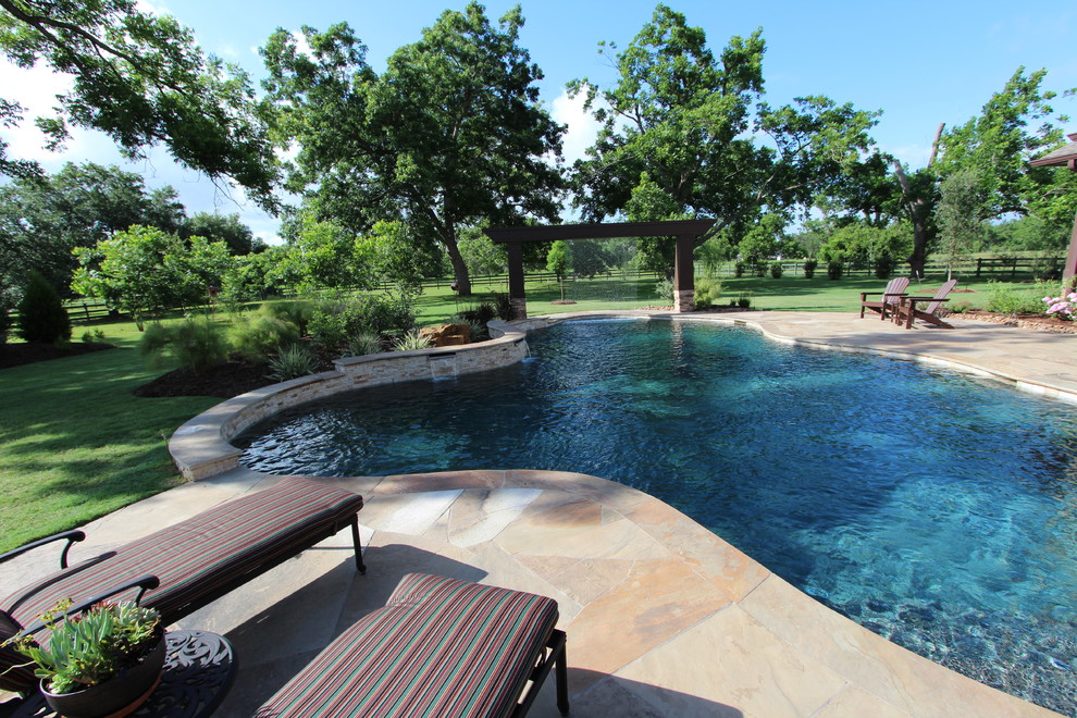 Pool fountain - large rustic backyard tile and custom-shaped pool fountain idea in Houston