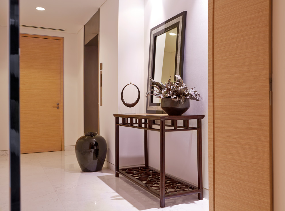 Design ideas for a large asian foyer in Singapore with white walls, marble floors, a double front door and a light wood front door.